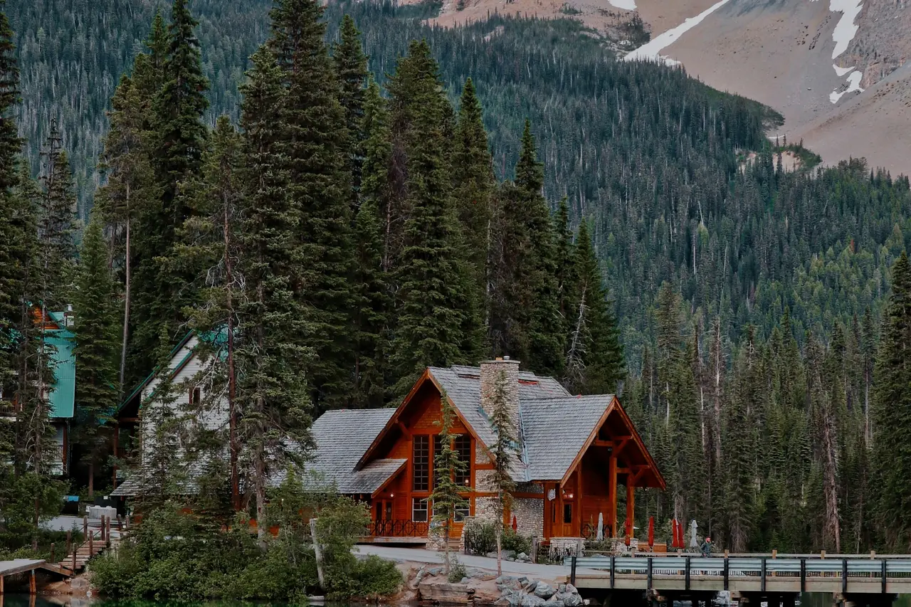 A red-roofed cabin and dock on Emerald Lake, BC, with a rocky peak behind