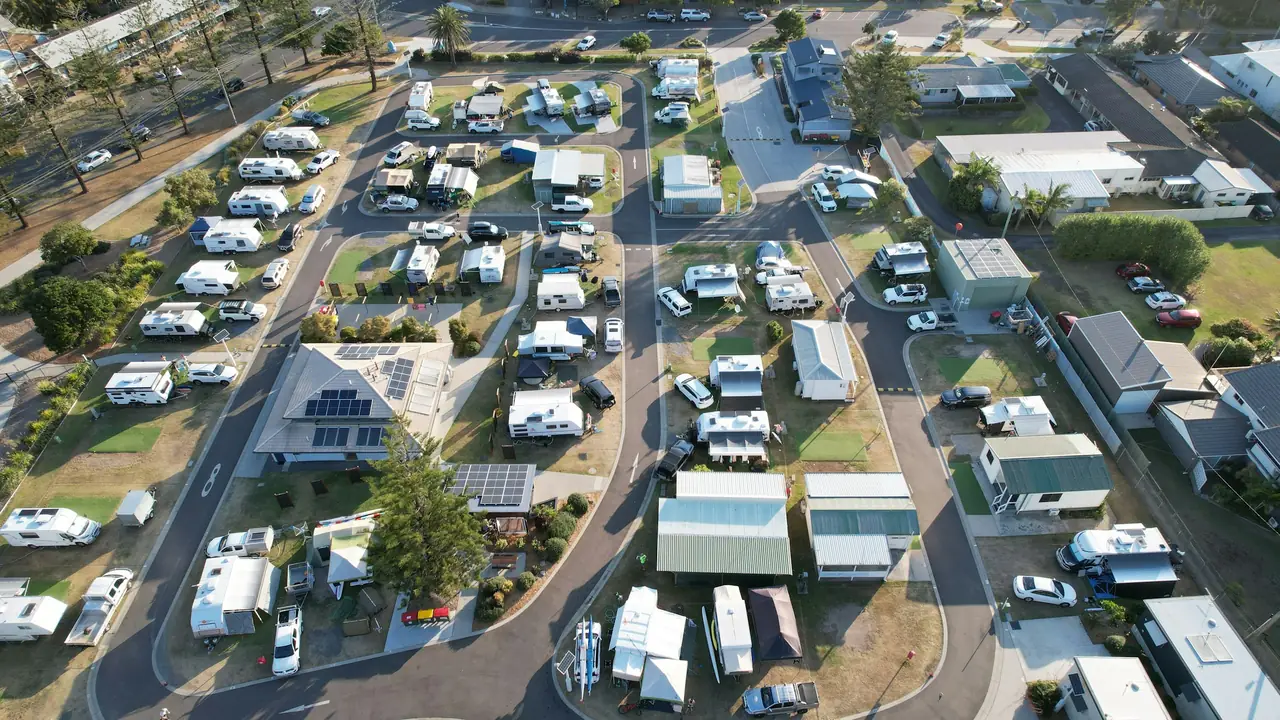 Aerial view of an RV park with rows of trailers, trees and small buildings